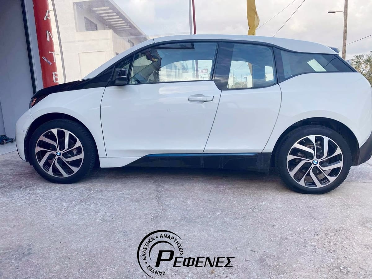 Λευκό BMW i3 με ψηλές, στενές ζάντες, στην πλάγια όψη